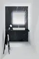 Waschtisch mit schwarzem Marmor-Wandpaneel von Ideal Standard, ausgestattet mit einem rechteckigen Spiegelschrank und einem modernen Waschbecken. Elegante Beleuchtung sorgt für zusätzliche Akzente.